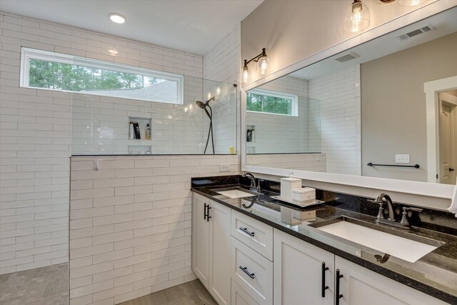 bathroom featuring tiled shower, hardwood / wood-style floors, tile walls, and a healthy amount of sunlight