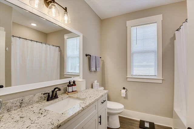 bathroom featuring hardwood / wood-style floors, vanity, toilet, and a wealth of natural light