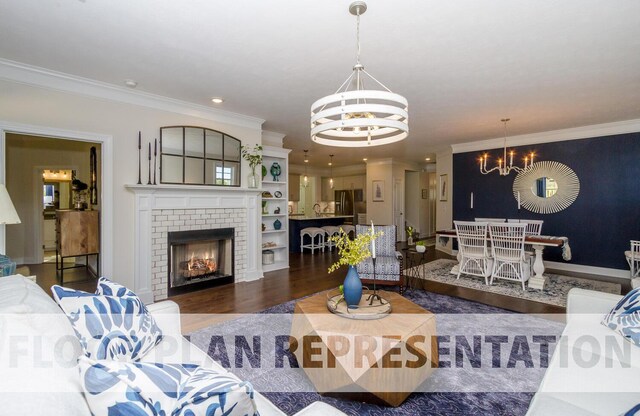 living room with a chandelier, dark hardwood / wood-style flooring, a fireplace, and ornamental molding