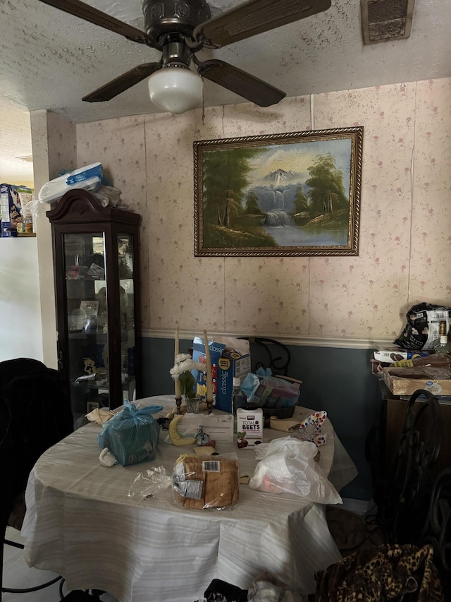3216 Alpine Rd, Augusta, GA 30909 - dining space with wallpapered walls, a textured ceiling, a ceiling fan, wainscoting, and visible vents