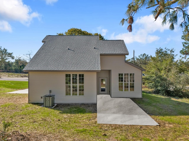 rear view of property featuring a patio area, a yard, and central AC unit