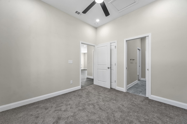 carpeted spare room featuring ceiling fan and a towering ceiling