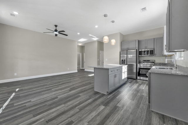 kitchen with gray cabinetry, sink, a center island, decorative light fixtures, and appliances with stainless steel finishes