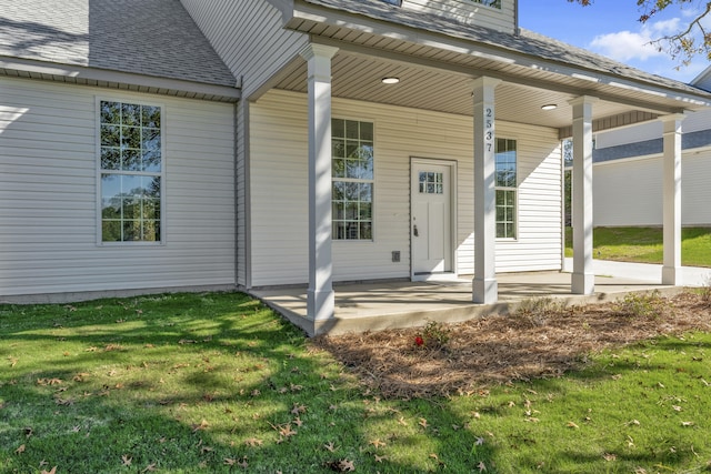 entrance to property with a yard and a porch