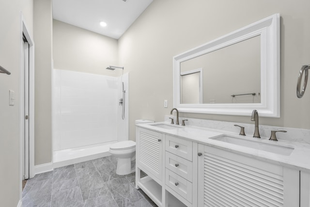 bathroom featuring vanity, toilet, and a shower