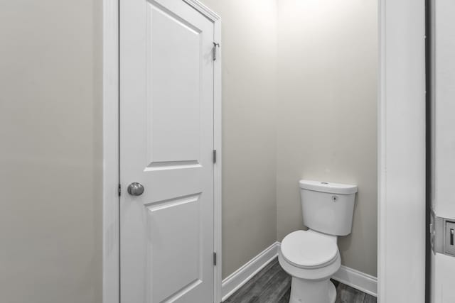 bathroom with hardwood / wood-style flooring and toilet