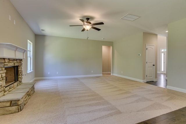 carpeted living room with ceiling fan and a fireplace