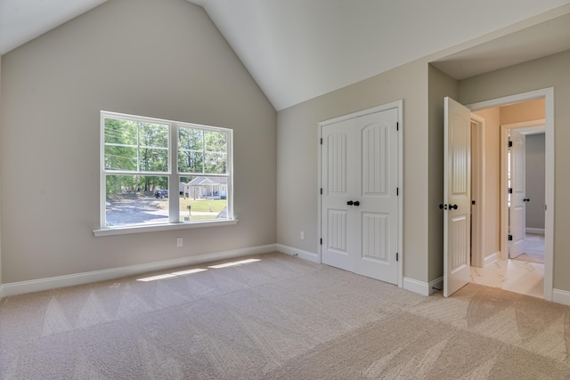 unfurnished bedroom with light carpet and vaulted ceiling