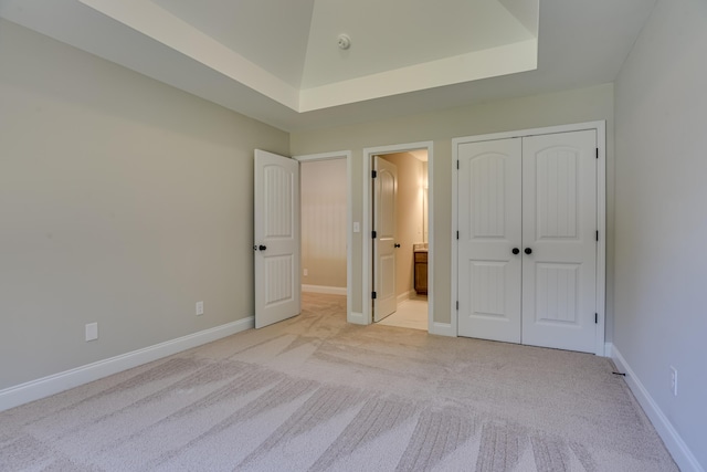 unfurnished bedroom with light colored carpet and a closet