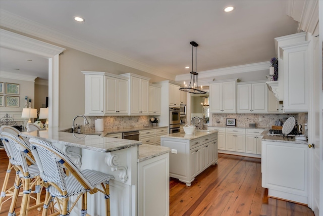 612 Emerald Xing, Evans, GA 30809 - kitchen with decorative backsplash, a peninsula, hardwood / wood-style flooring, light stone counters, and crown molding