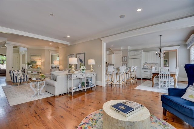 612 Emerald Xing, Evans, GA 30809 - living area with ornamental molding, a chandelier, decorative columns, wood finished floors, and recessed lighting