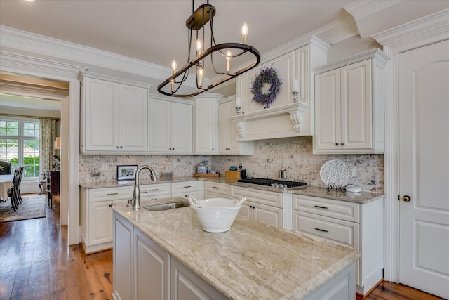 612 Emerald Xing, Evans, GA 30809 - kitchen with stainless steel gas stovetop, a chandelier, light wood-style floors, backsplash, and white cabinets