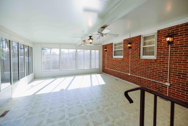 unfurnished sunroom featuring beamed ceiling