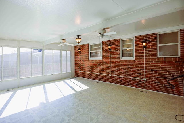 unfurnished sunroom with ceiling fan and beam ceiling