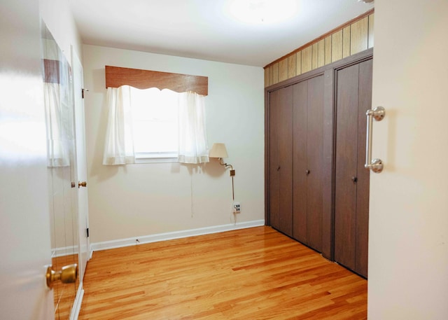 unfurnished bedroom with light hardwood / wood-style flooring and two closets