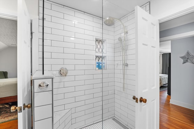 full bathroom featuring ensuite bath, tiled shower, and wood finished floors