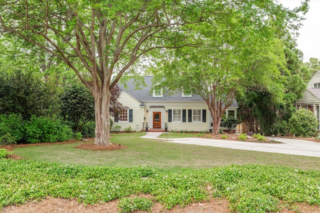 view of front of house with a front yard and roof with shingles