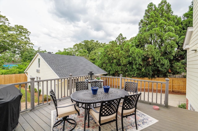 wooden terrace featuring a fenced backyard, outdoor dining area, and grilling area