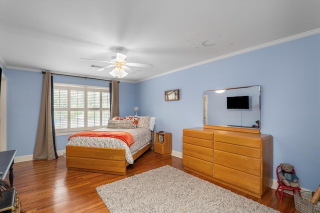 bedroom featuring wood finished floors, baseboards, and crown molding