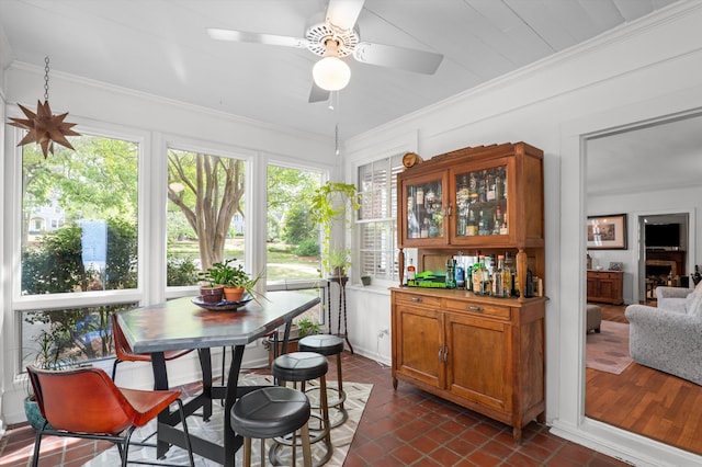 sunroom featuring healthy amount of natural light, ornamental molding, and tile patterned flooring