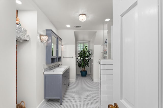 full bath featuring vanity, a walk in shower, and baseboards