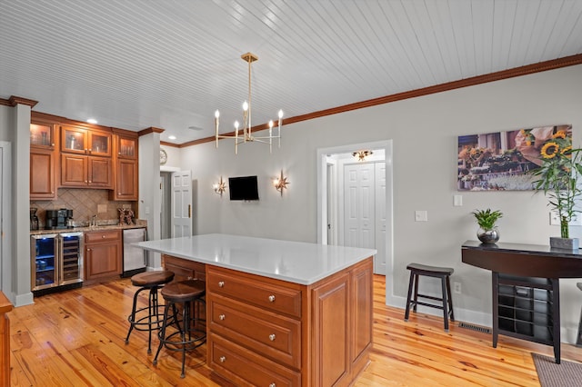 kitchen featuring wine cooler, brown cabinetry, light wood-style flooring, ornamental molding, and tasteful backsplash