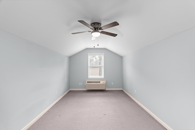 additional living space with a wall mounted AC, vaulted ceiling, a ceiling fan, baseboards, and carpet floors