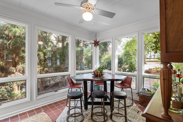 sunroom / solarium with healthy amount of natural light, tile patterned floors, and ornamental molding