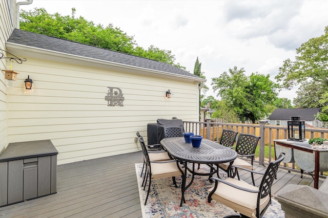 wooden terrace with outdoor dining area and fence