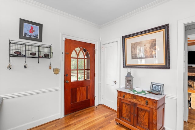 foyer entrance featuring light wood-style flooring and crown molding