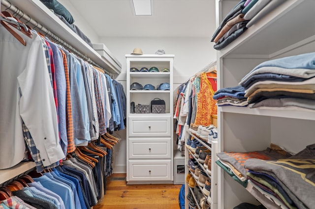 walk in closet with light wood finished floors