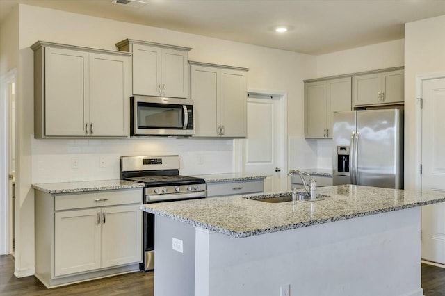 kitchen with light stone countertops, sink, appliances with stainless steel finishes, and dark wood-type flooring