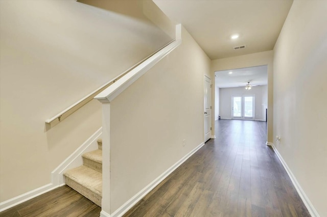 stairs featuring hardwood / wood-style floors, ceiling fan, and french doors