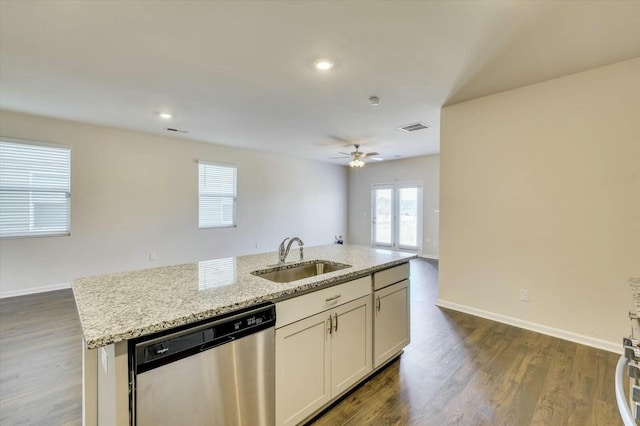 kitchen with light stone counters, ceiling fan, sink, dishwasher, and an island with sink