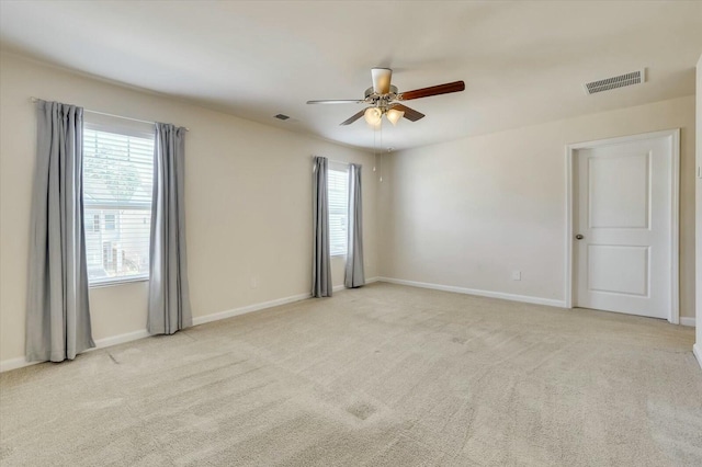 empty room with ceiling fan and light carpet