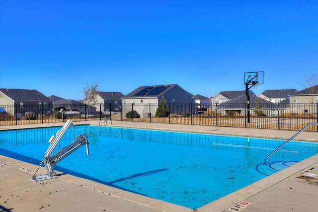 view of swimming pool with basketball hoop