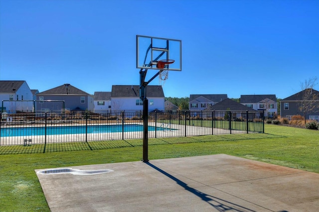 view of sport court with a community pool and a lawn