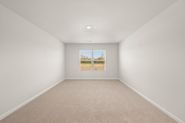 spare room featuring light colored carpet