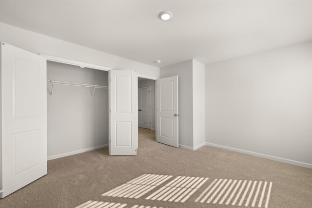 unfurnished bedroom with light carpet and a closet