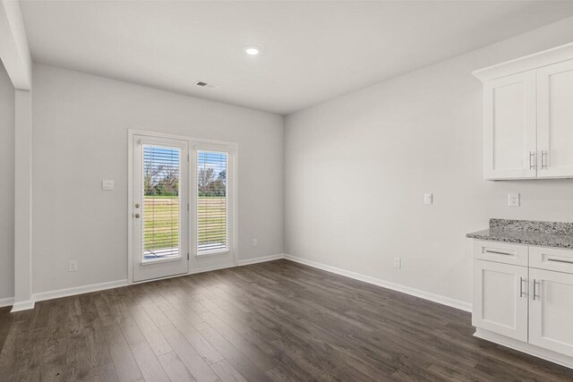 unfurnished dining area with dark hardwood / wood-style flooring