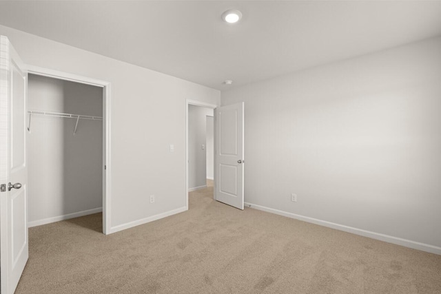 unfurnished bedroom with light carpet and a closet