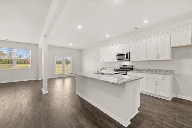 kitchen featuring white cabinets, sink, dark hardwood / wood-style floors, an island with sink, and appliances with stainless steel finishes