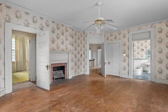 2131 Gardner St, Augusta, GA 30904 - unfurnished living room featuring wood finished floors, ceiling fan, wallpapered walls, a brick fireplace, and ornamental molding