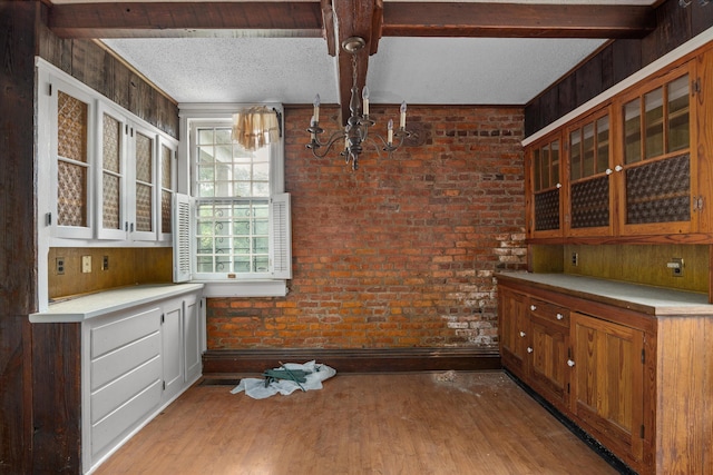 2131 Gardner St, Augusta, GA 30904 - kitchen featuring a chandelier, beamed ceiling, wood finished floors, glass insert cabinets, and light countertops