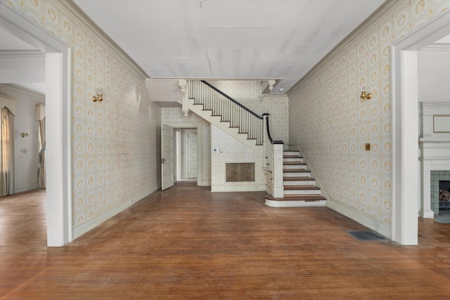 2131 Gardner St, Augusta, GA 30904 - unfurnished living room featuring wallpapered walls, a tiled fireplace, stairs, wood finished floors, and baseboards
