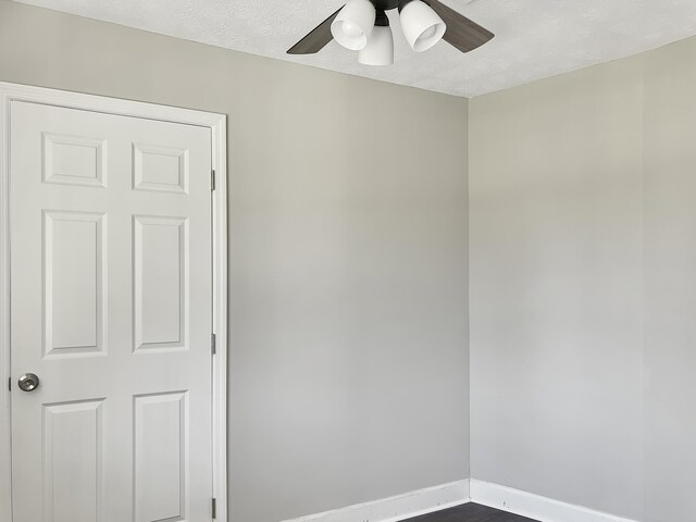 spare room featuring hardwood / wood-style floors, ceiling fan, and a textured ceiling