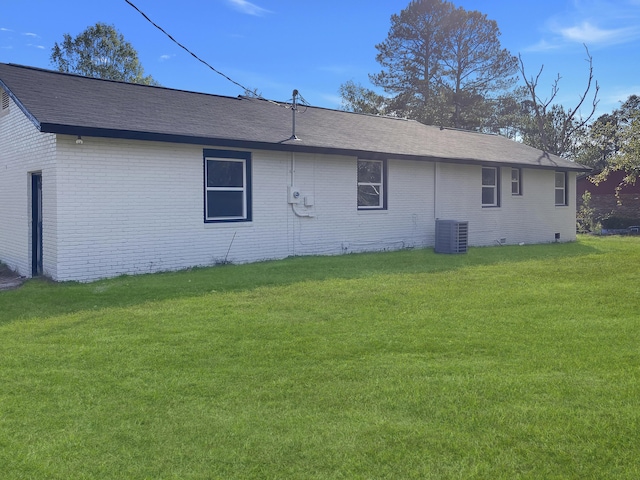 view of property exterior with central AC and a yard