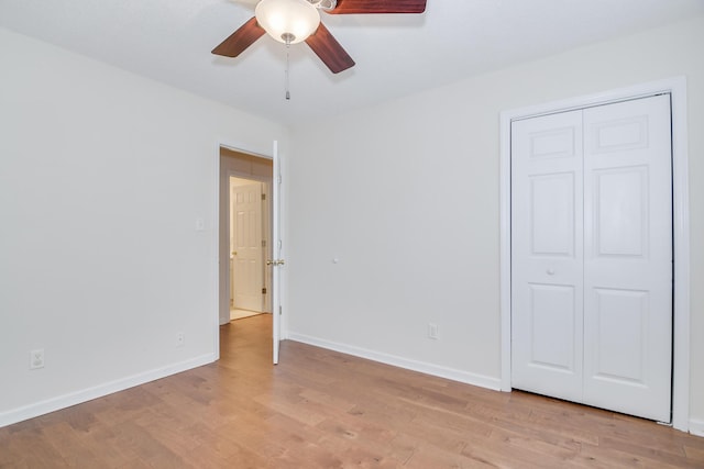 unfurnished bedroom with light hardwood / wood-style floors, a closet, and ceiling fan