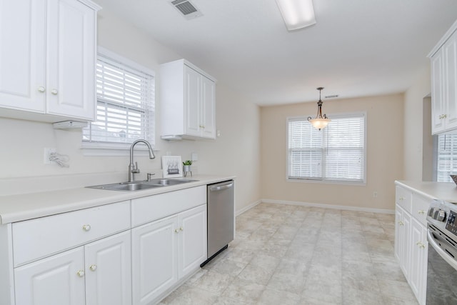 kitchen featuring sink, white cabinetry, hanging light fixtures, appliances with stainless steel finishes, and a wealth of natural light