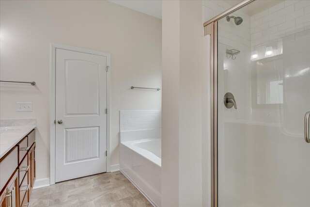 bathroom with vanity, a stall shower, and a bath